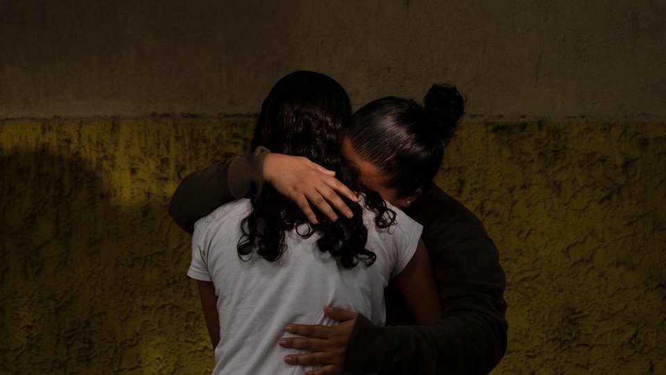 Two women holding each other in comfort